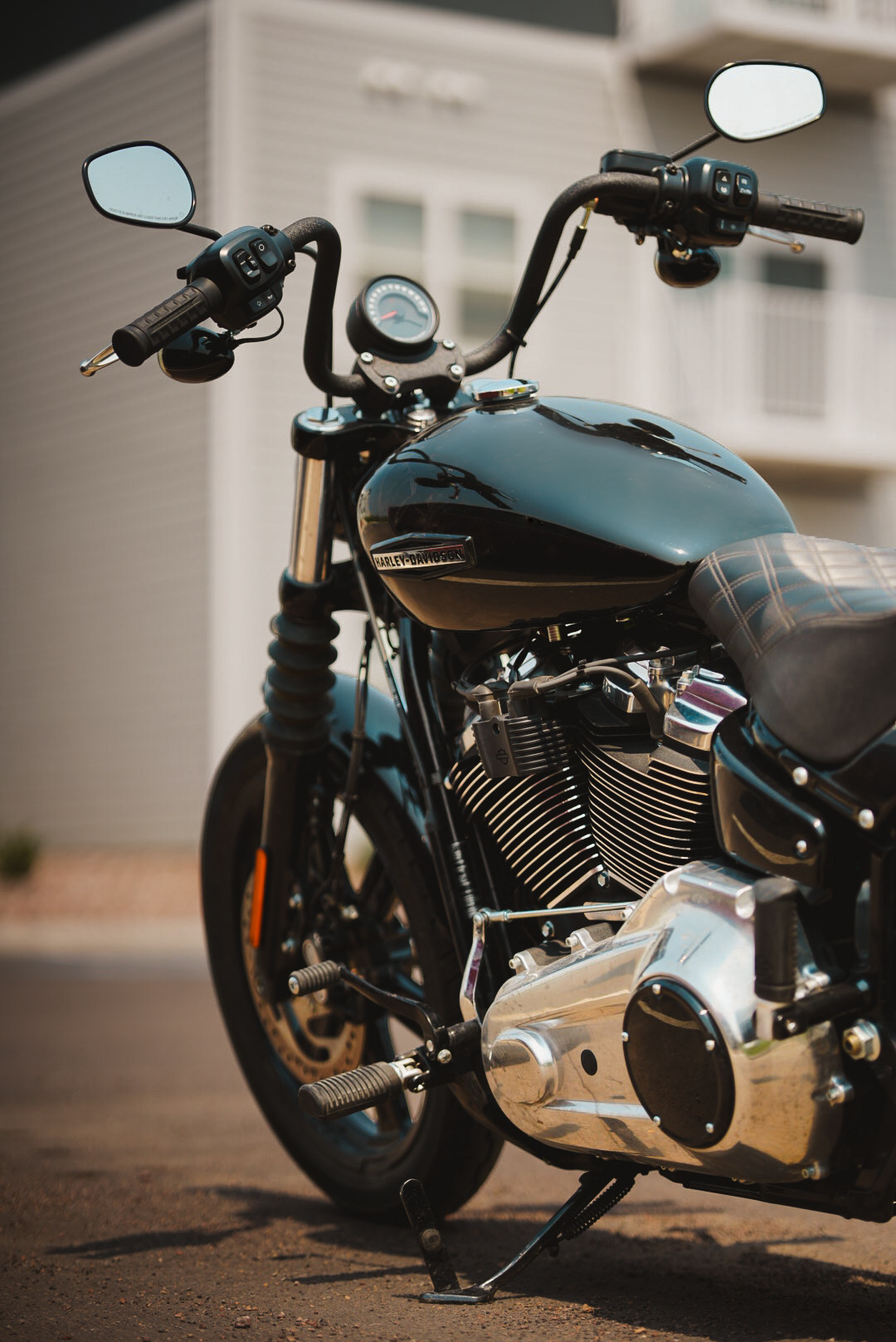 Black Harley-Davidson Sportster parked on a driveway in warm haze