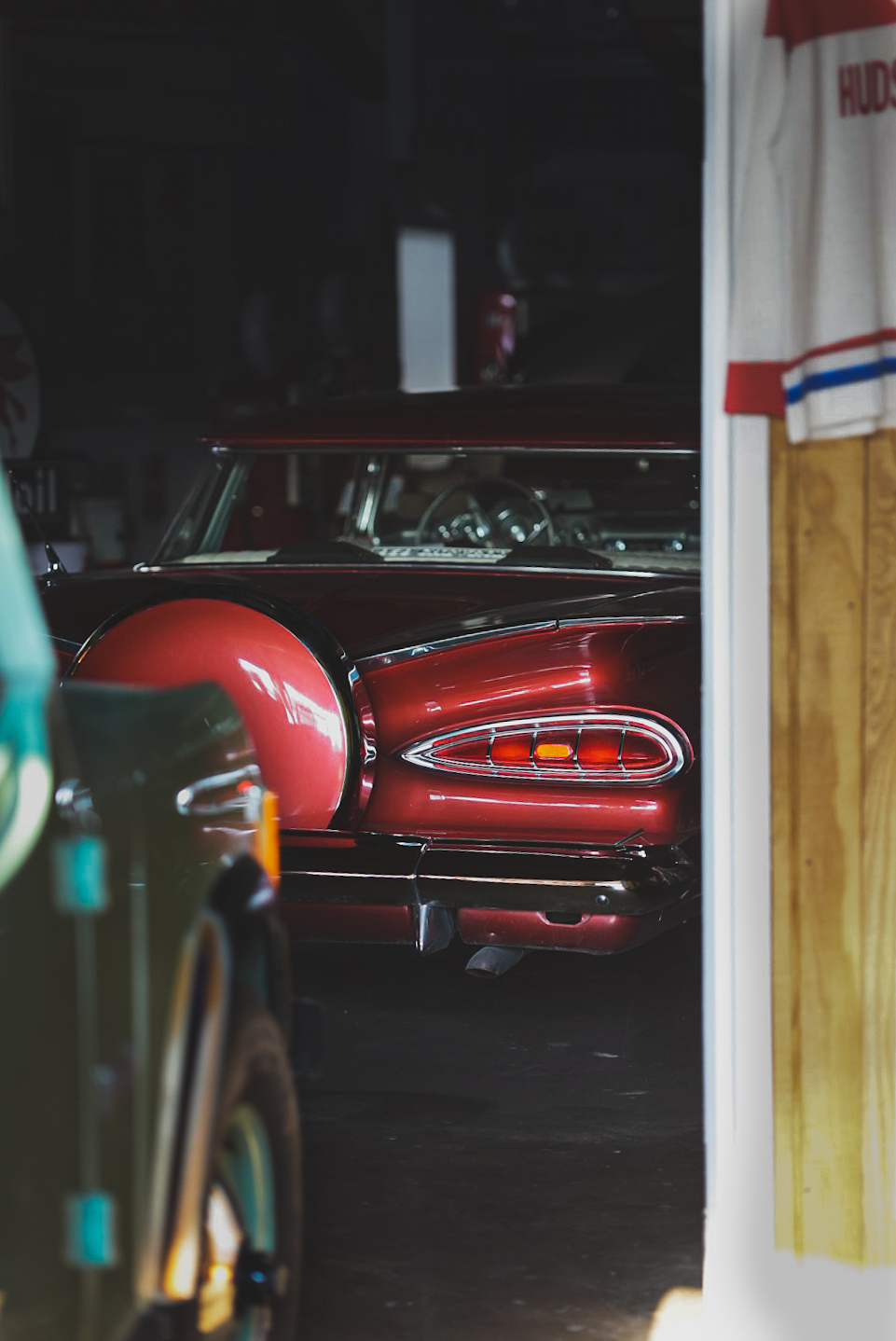 Red 1959 Chevrolet Impala taillight glowing in a dim garage