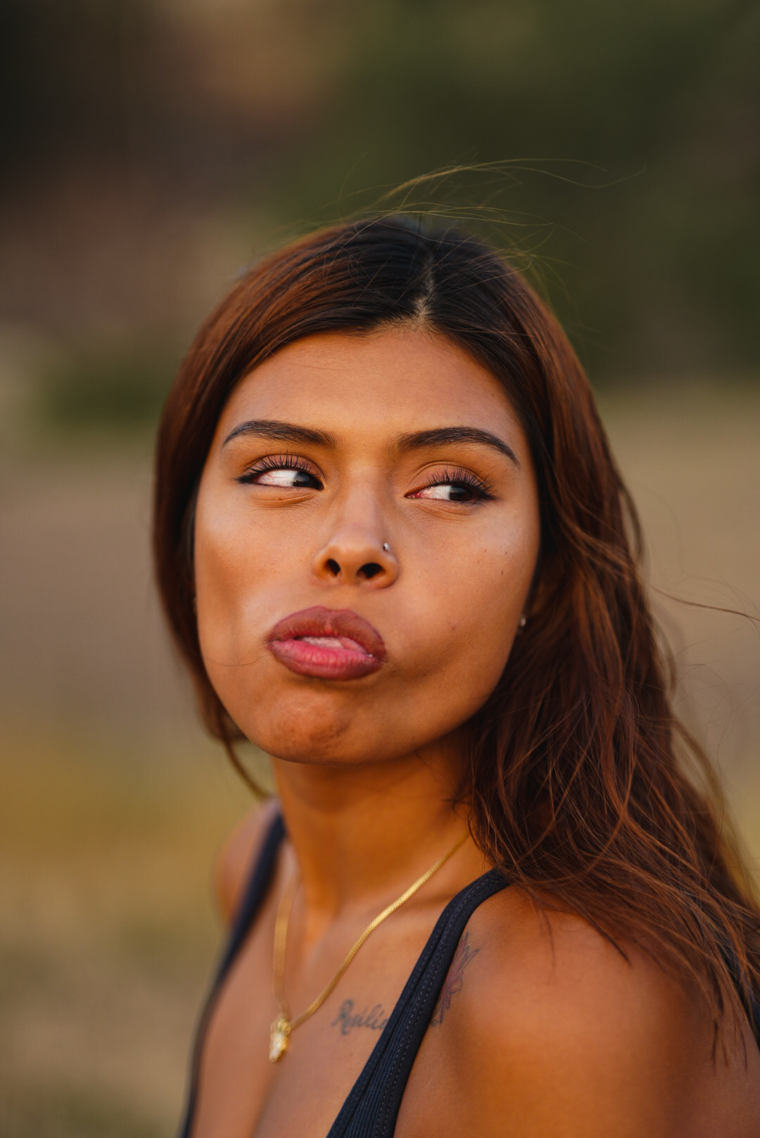 Close-up portrait of a woman making a playful face in warm golden light