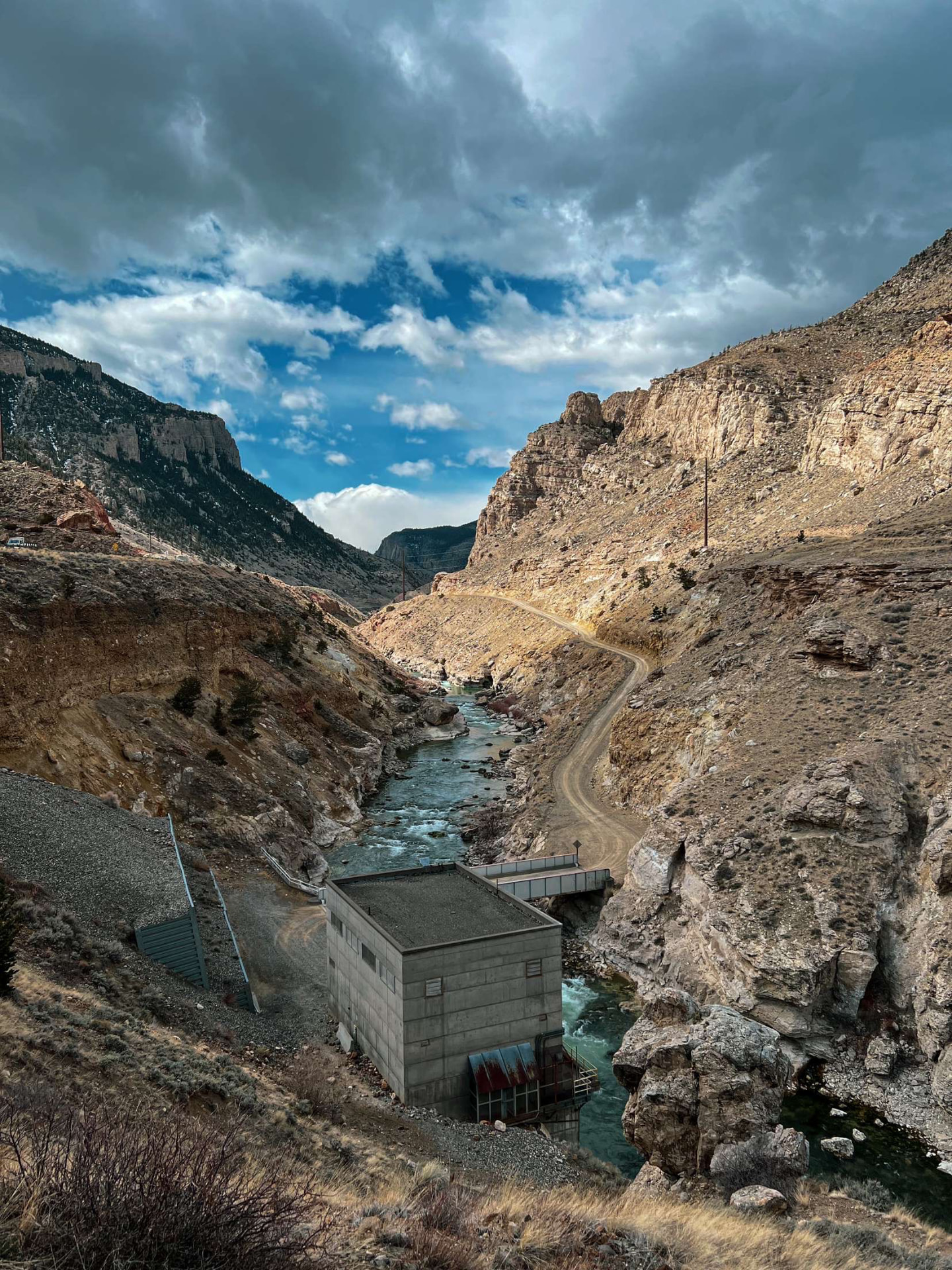River winding through a steep desert canyon beneath dramatic clouds
