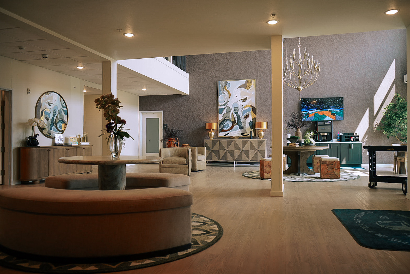 Open apartment lobby with curved seating, artwork and warm afternoon light