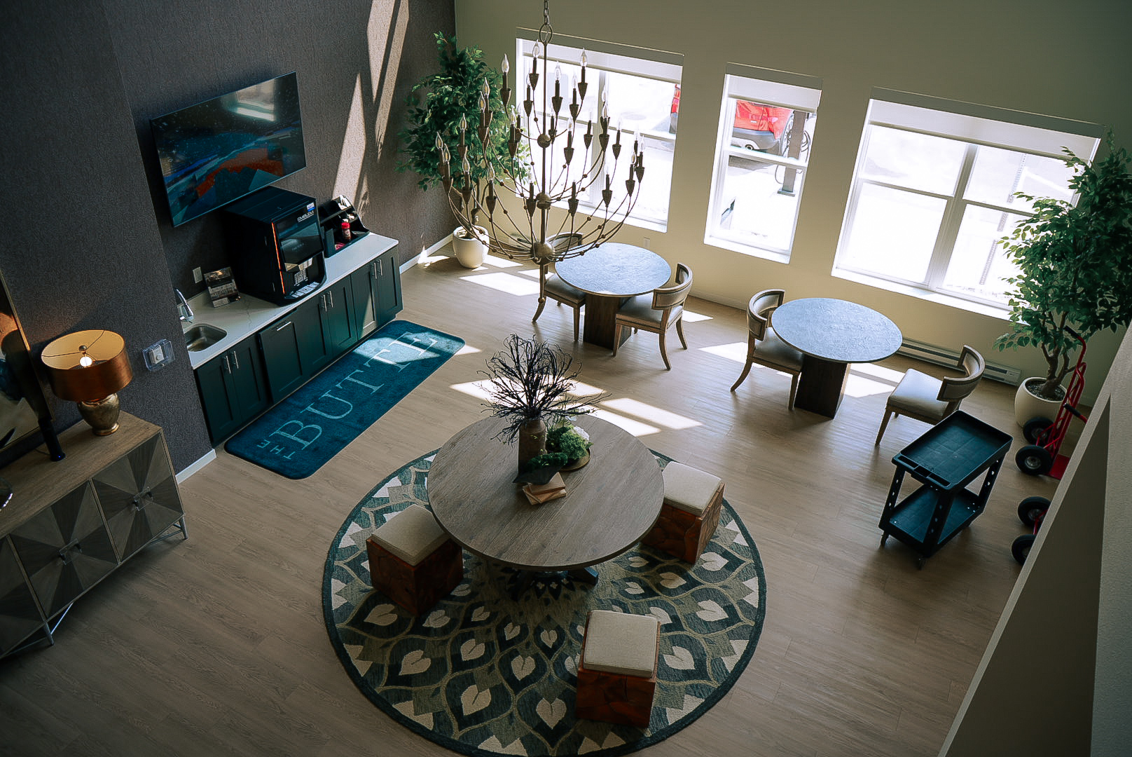 Elevated view of a lounge with round tables, chandelier and patterned rugs