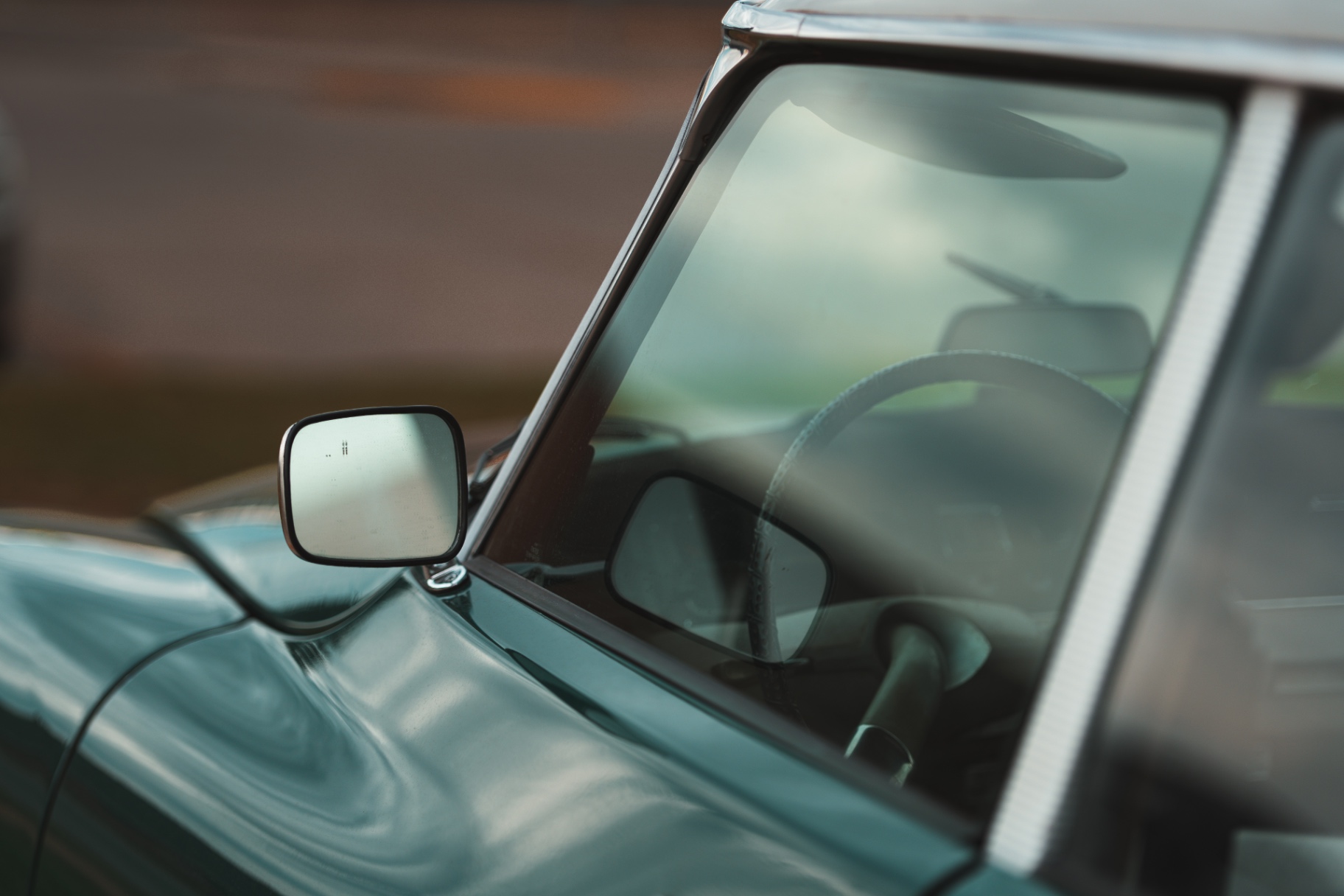 Side mirror and windshield detail of a green vintage Citroen