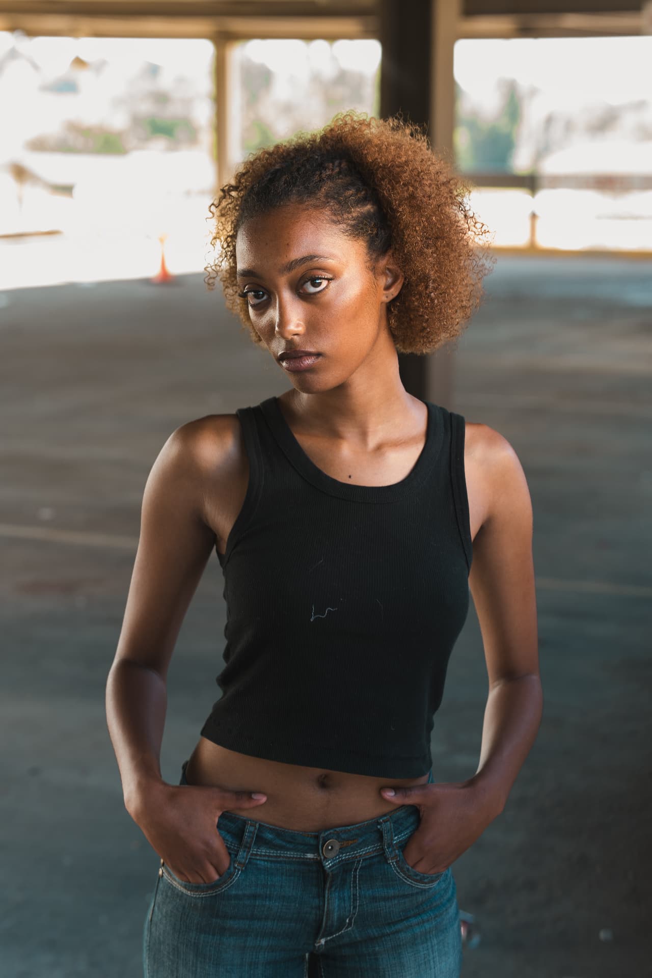Portrait of a woman standing in an open concrete structure lit by daylight