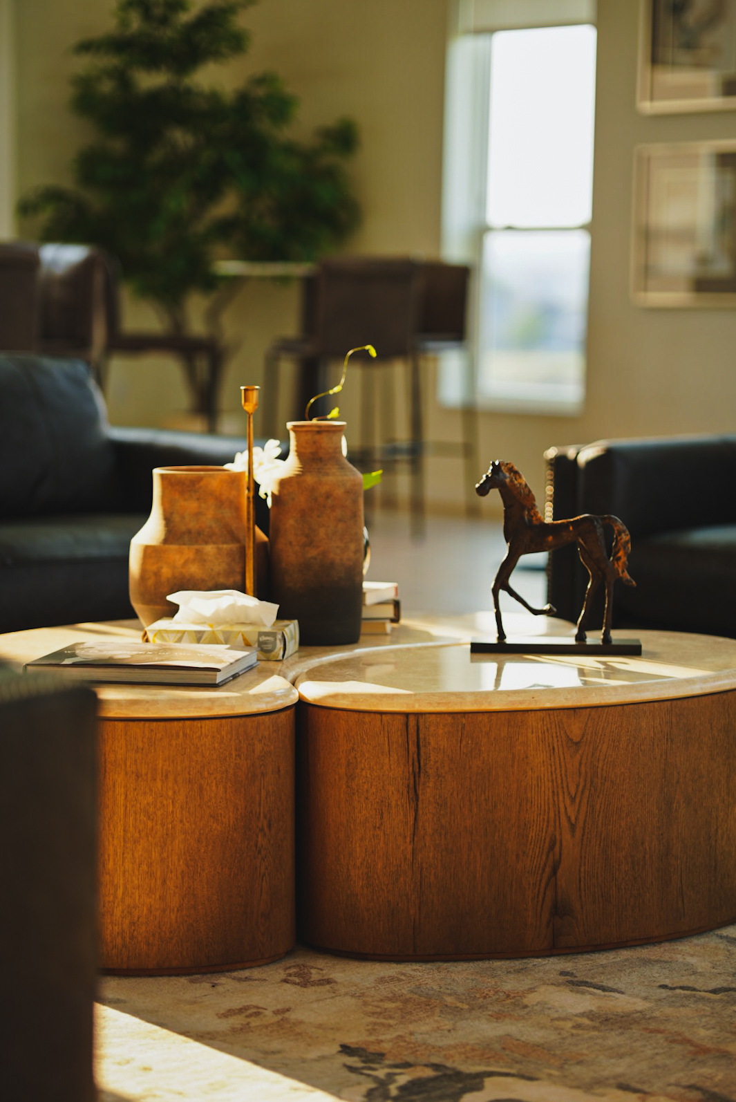 Coffee table styled with ceramic vases, books and a bronze horse sculpture