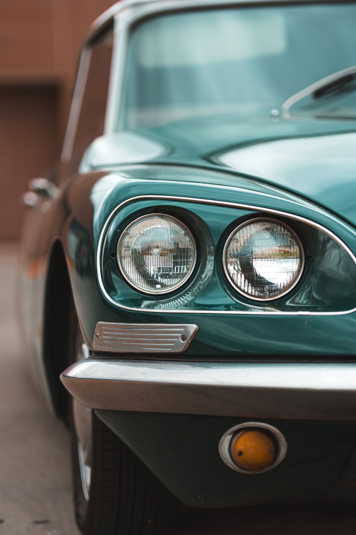 Close-up of the dual headlights on a green Citroen DS