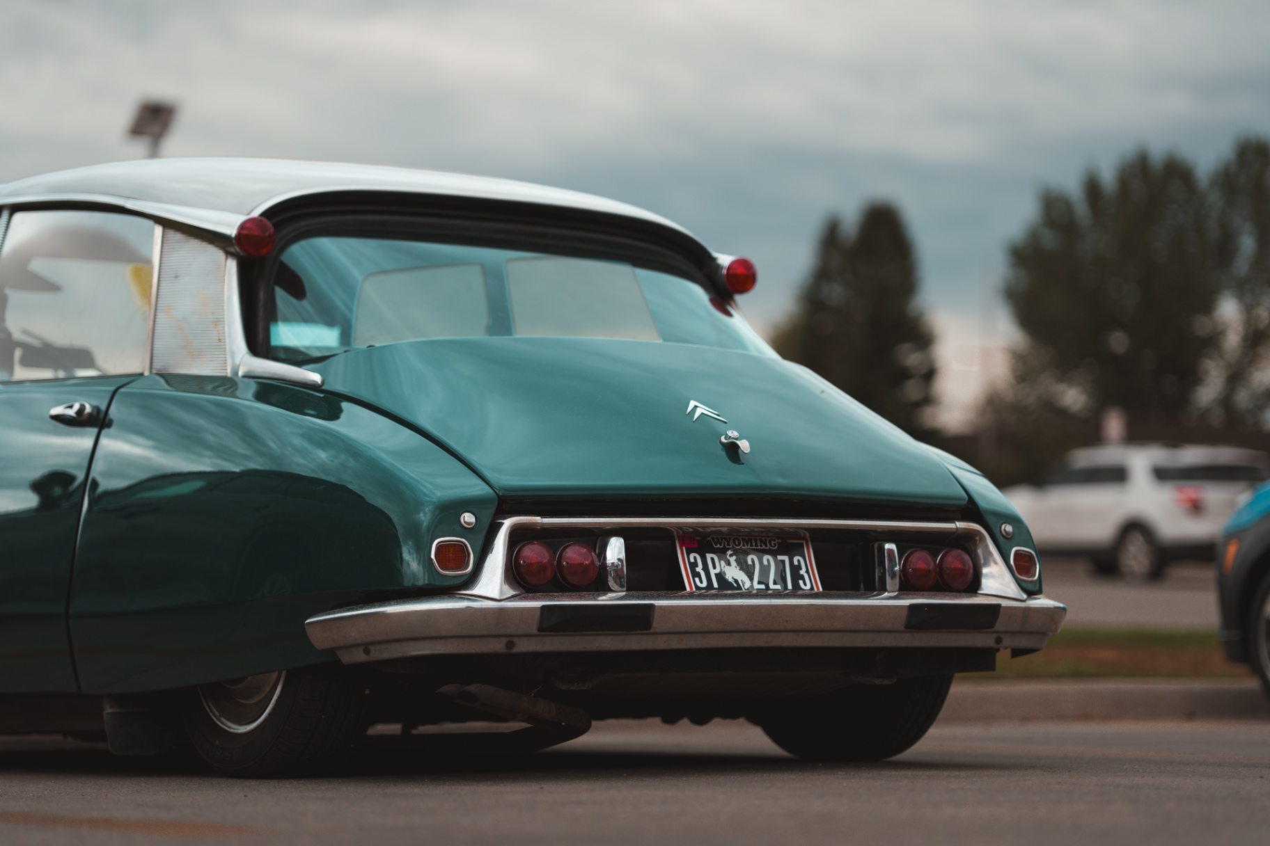 Rear of a green and white Citroen DS with chrome bumper and tail lamps
