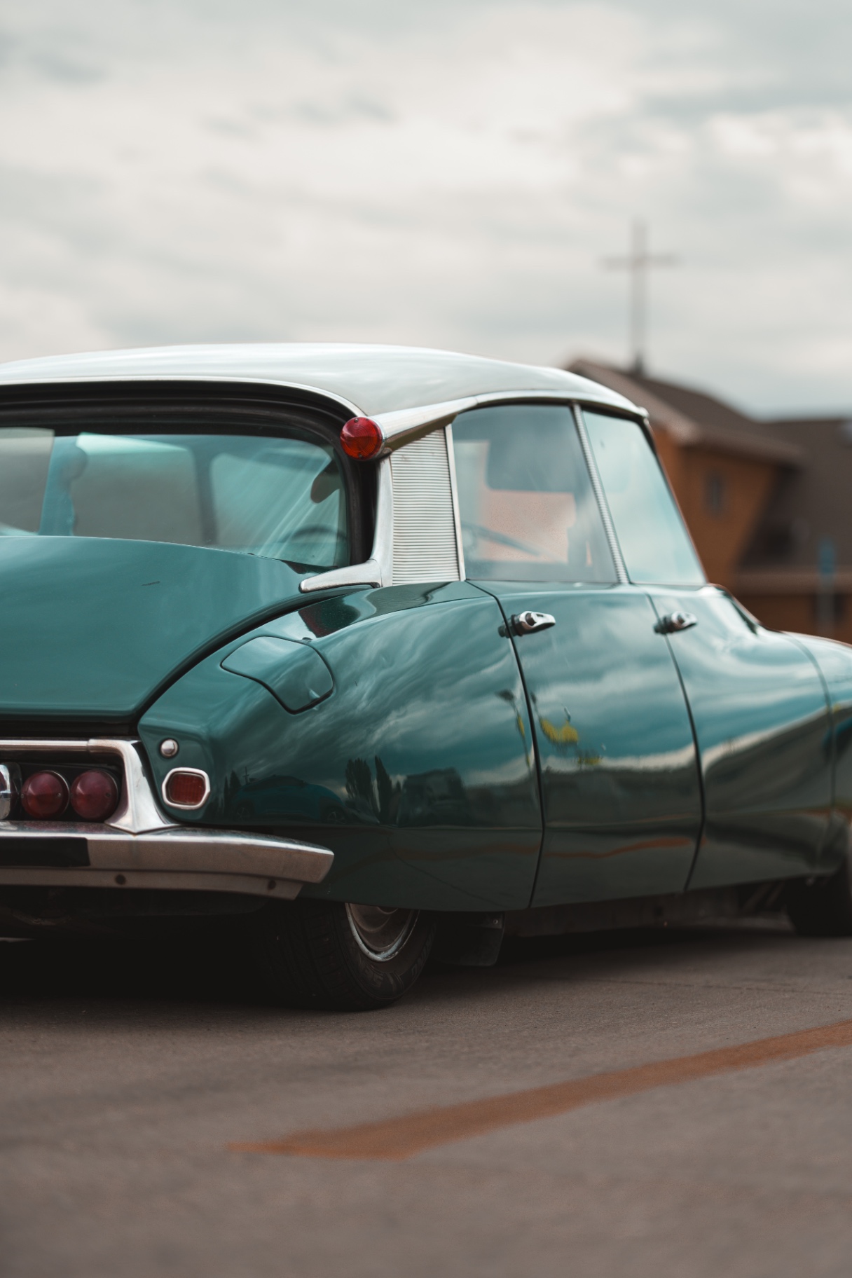 Rear three-quarter view of a green Citroen DS under an overcast sky